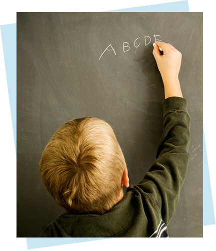 Child writing on chalkboard